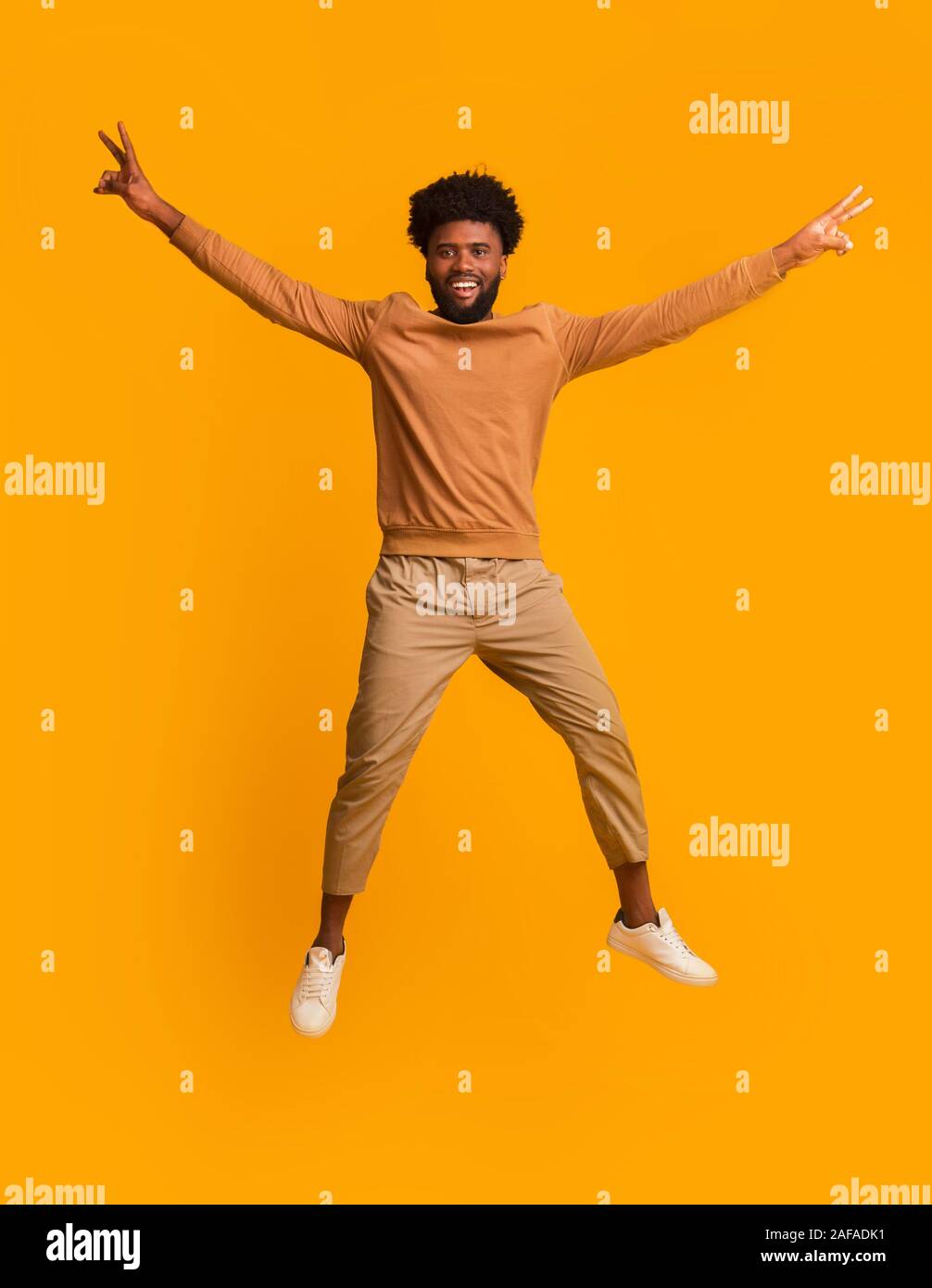 Black Cheerful Guy Jumping Up With Raised Hands Stock Photo Alamy