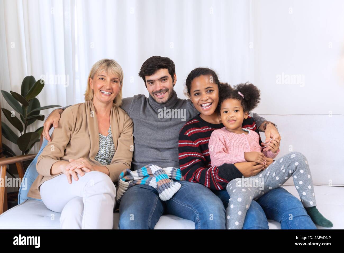 happy family spending time together on sofa in living room. family and home concept Stock Photo
