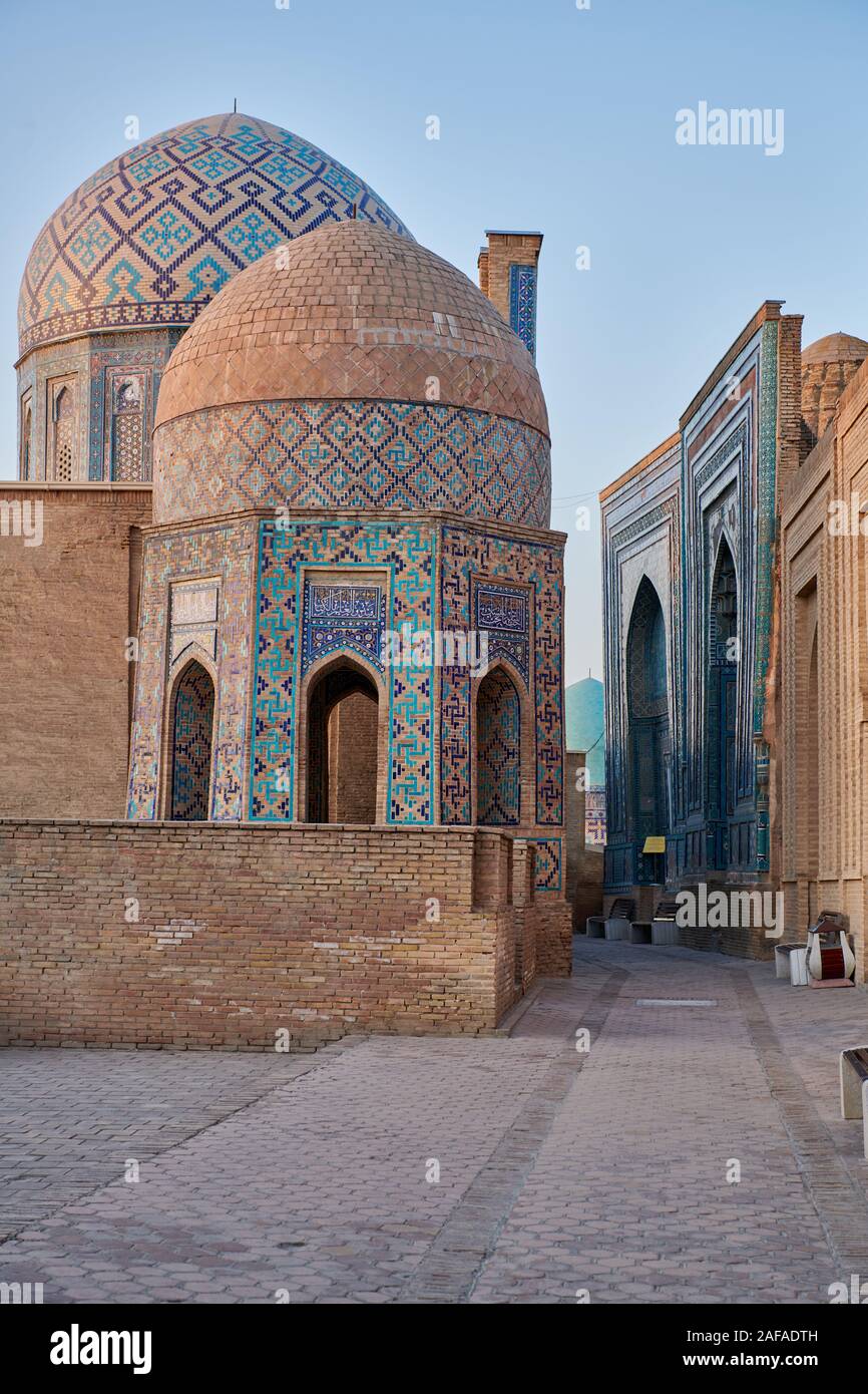 Shirin Biqa Aqa or Octagonal Mausoleum and narrow path through facades heavily decorated with blue tiles in necropolis Shah-i-Zinda, Samarqand, Uzbeki Stock Photo