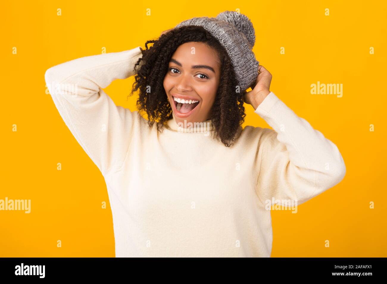 Woman wearing yellow beanie sweater hi-res stock photography and images ...