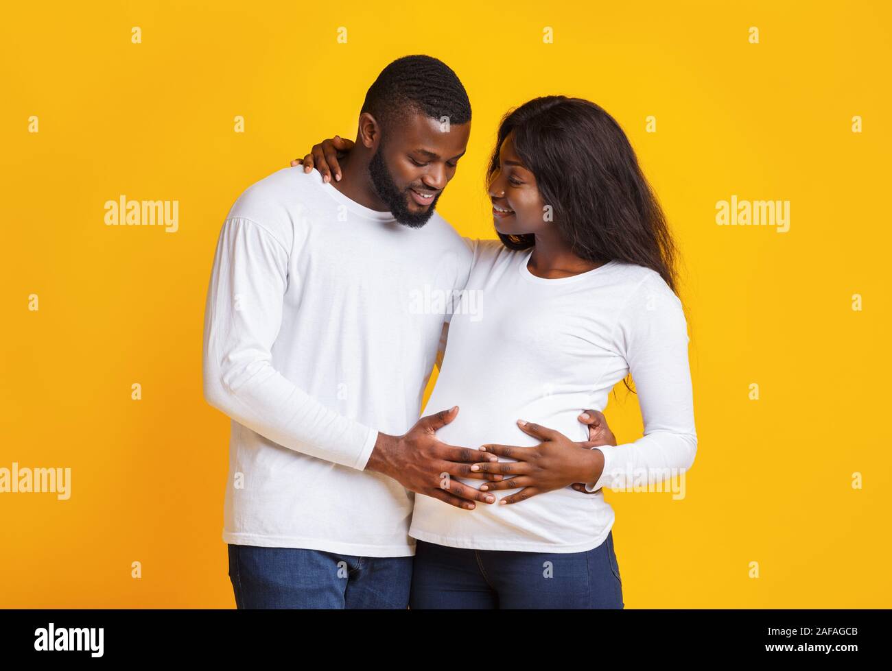 Man in love touching his pregnant wife tummy Stock Photo