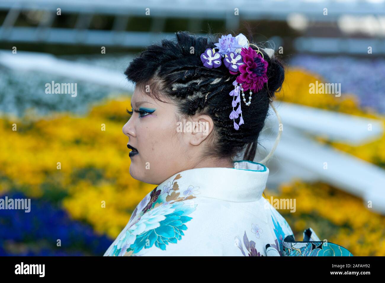 Beautiful Japanese teenager wearing traditional kimono looking sideways with close-up on hair ornament celebrating the Coming of Age Day in Fuji City, Stock Photo
