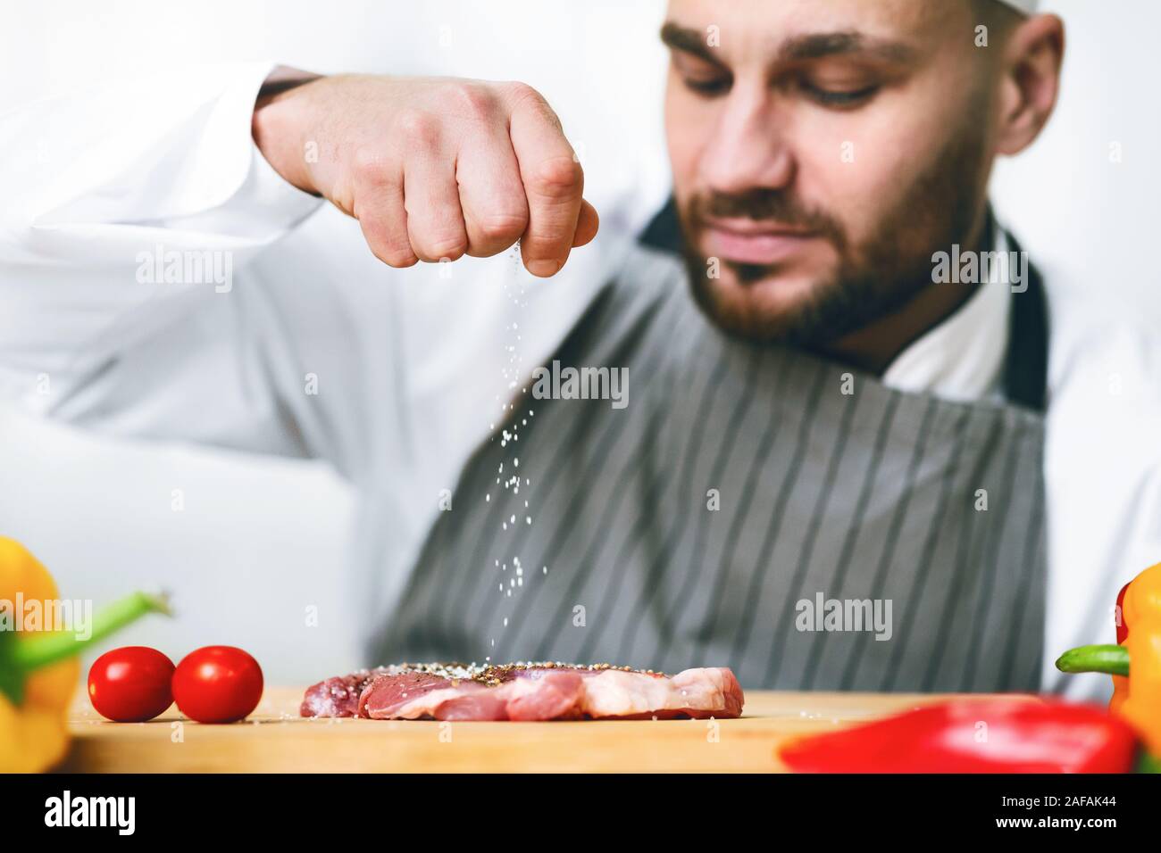 Chef Man Seasoning Meat Cooking Food In Restaurant Kitchen Indoor Stock