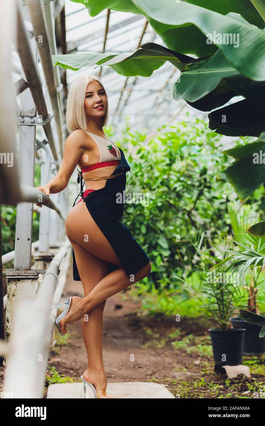 pretty young woman gardening in an apron, without clothes Stock Photo -  Alamy