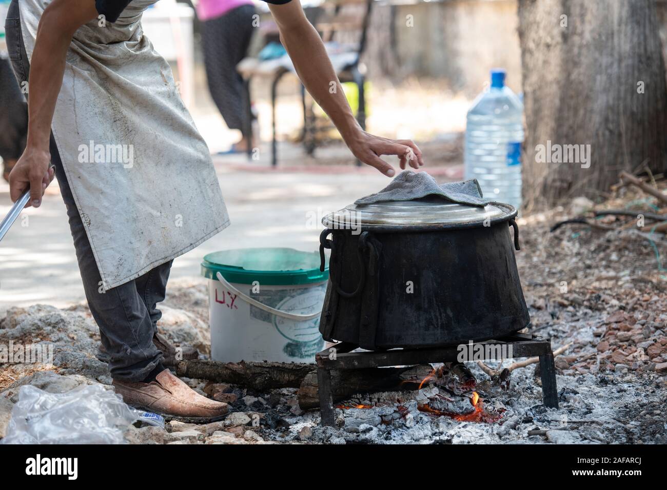A pot of food on a fire, being prepared for a funeral party in a rural