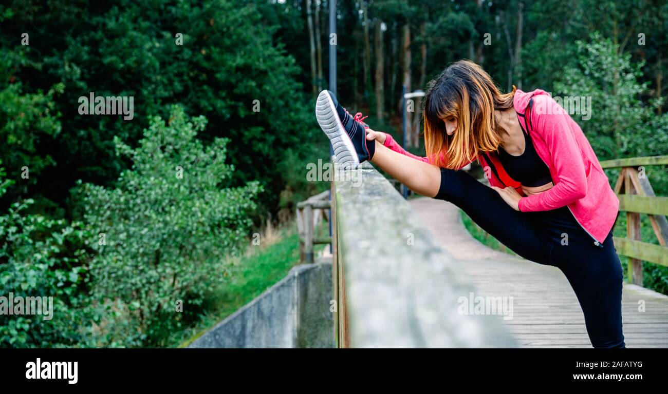 Athlete woman doing leg stretch Stock Photo