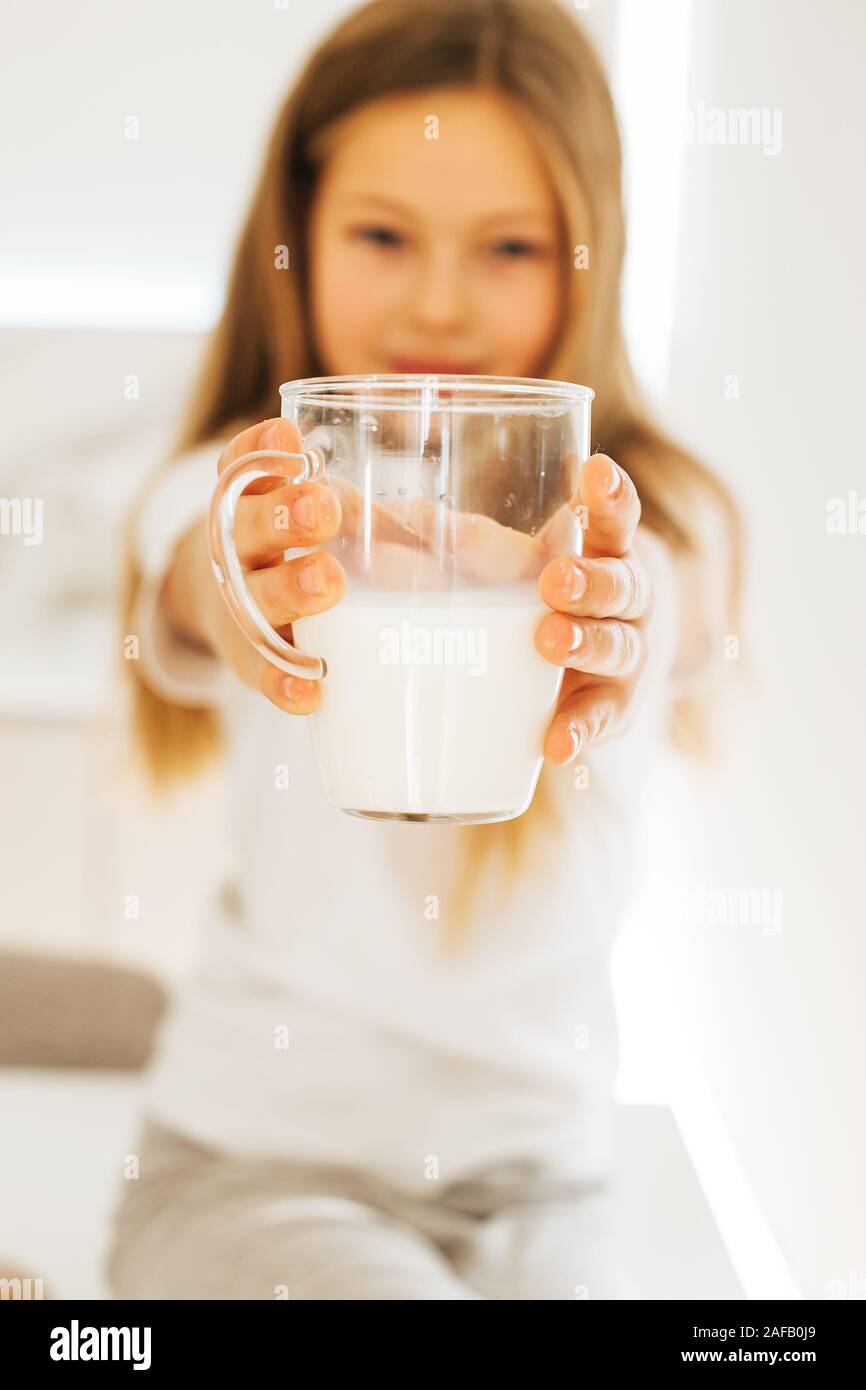 Smiling little girl drinking milk Stock Photo