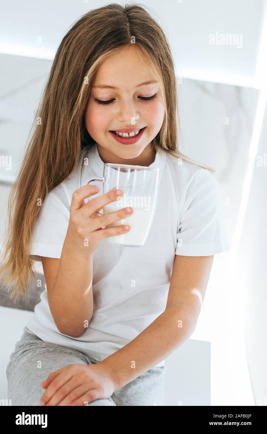 Smiling little girl drinking milk Stock Photo