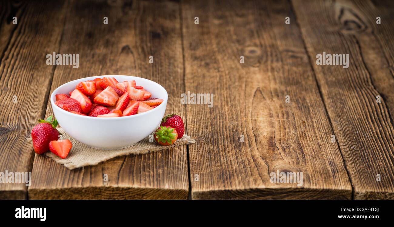 Fresh made Chopped Strawberries on an old and rustic wooden table ...