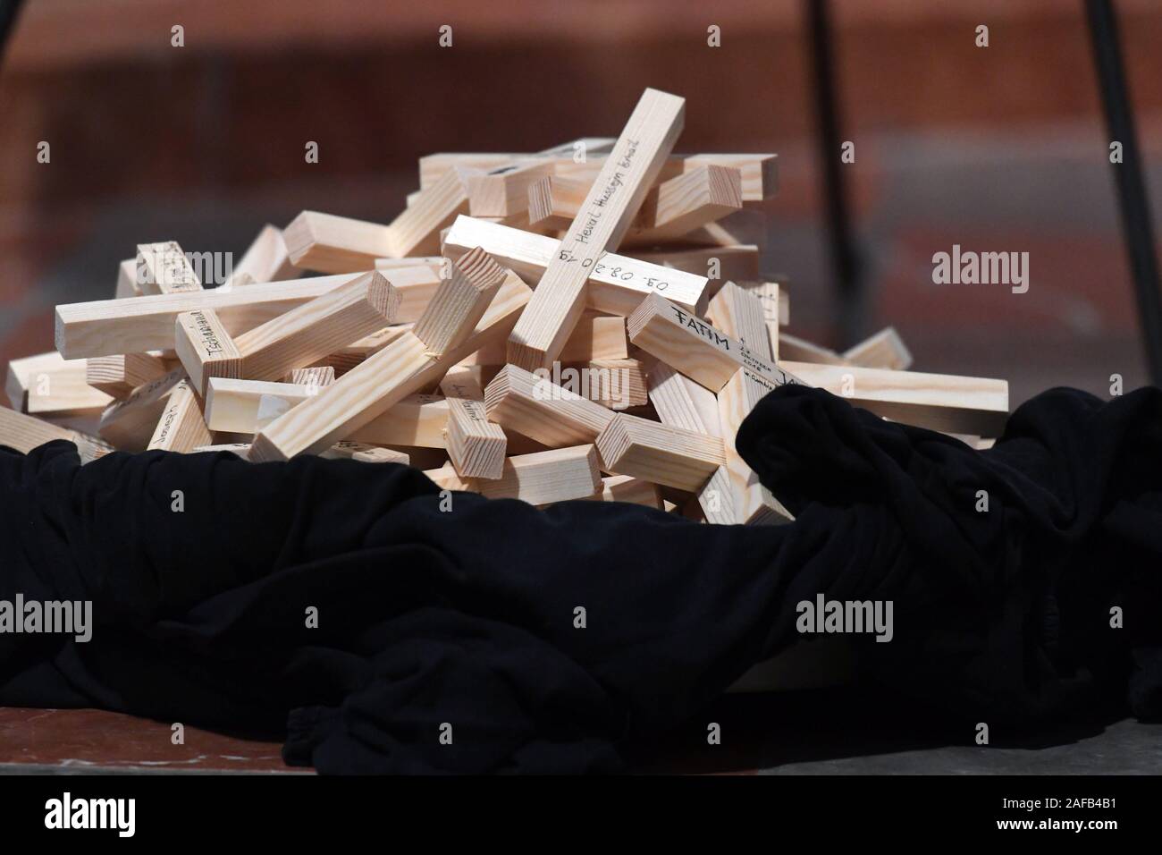 Munich, Germany. 14th Dec, 2019. Wooden crosses, on which the names of the dead in the Mediterranean Sea are written, lie on a black cloth in Munich Cathedral during the ecumenical service commemorating the dead in the Mediterranean Sea. Credit: Felix Hörhager/dpa/Alamy Live News Stock Photo