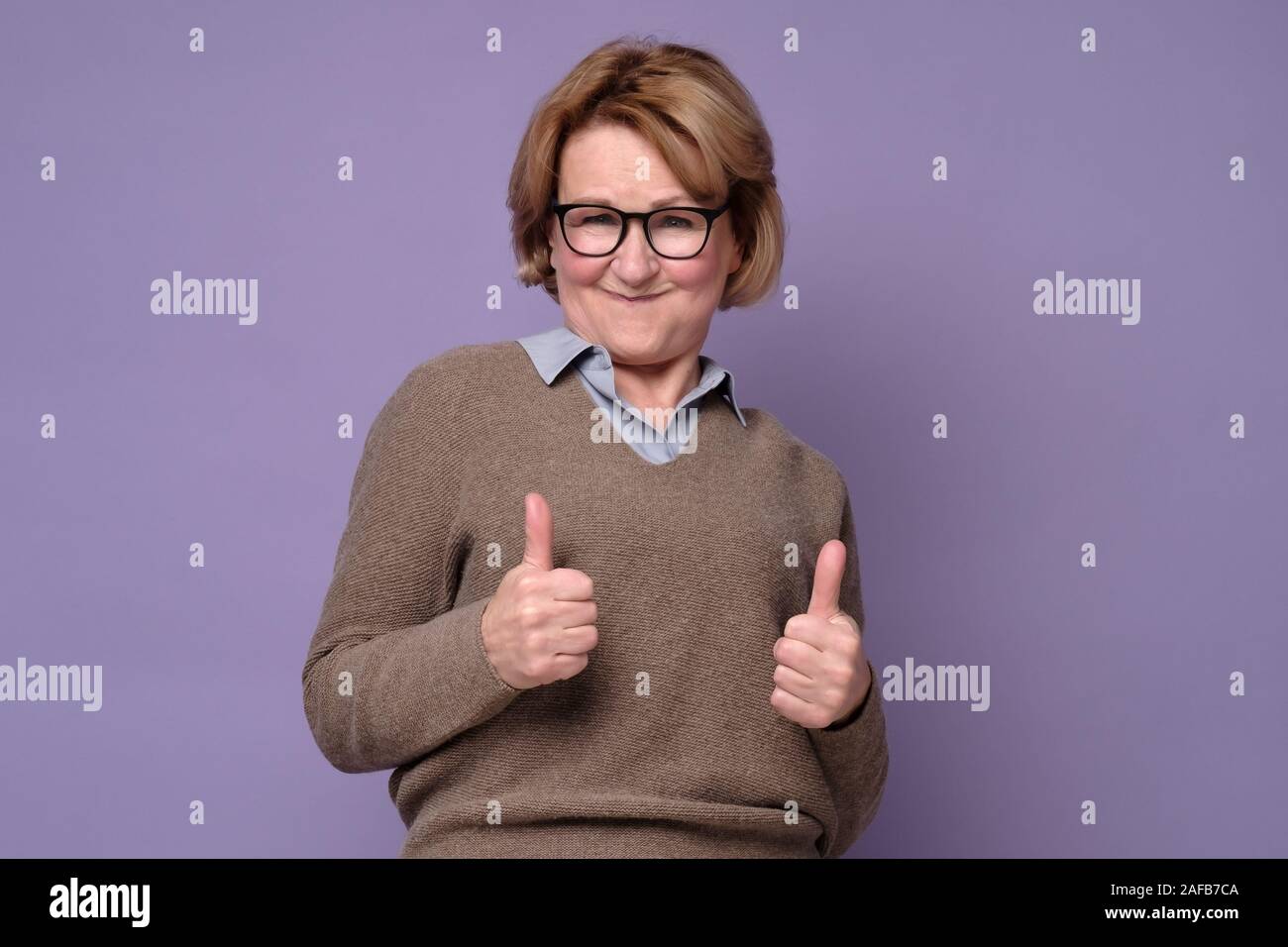 Old woman giving thumbs up hi-res stock photography and images - Alamy