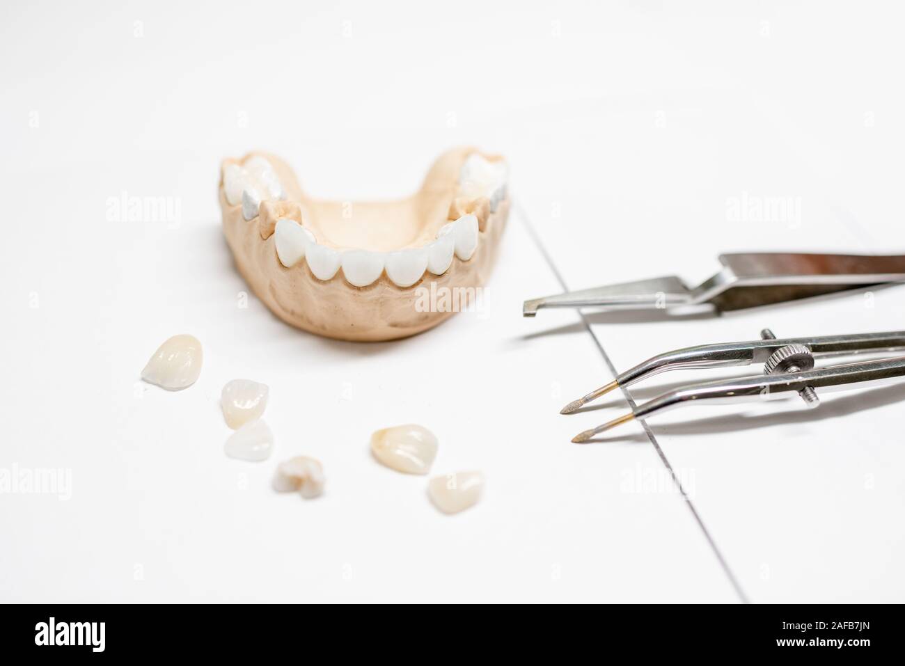 Artificial plaster jaw model with veneers and dental instruments on the ...