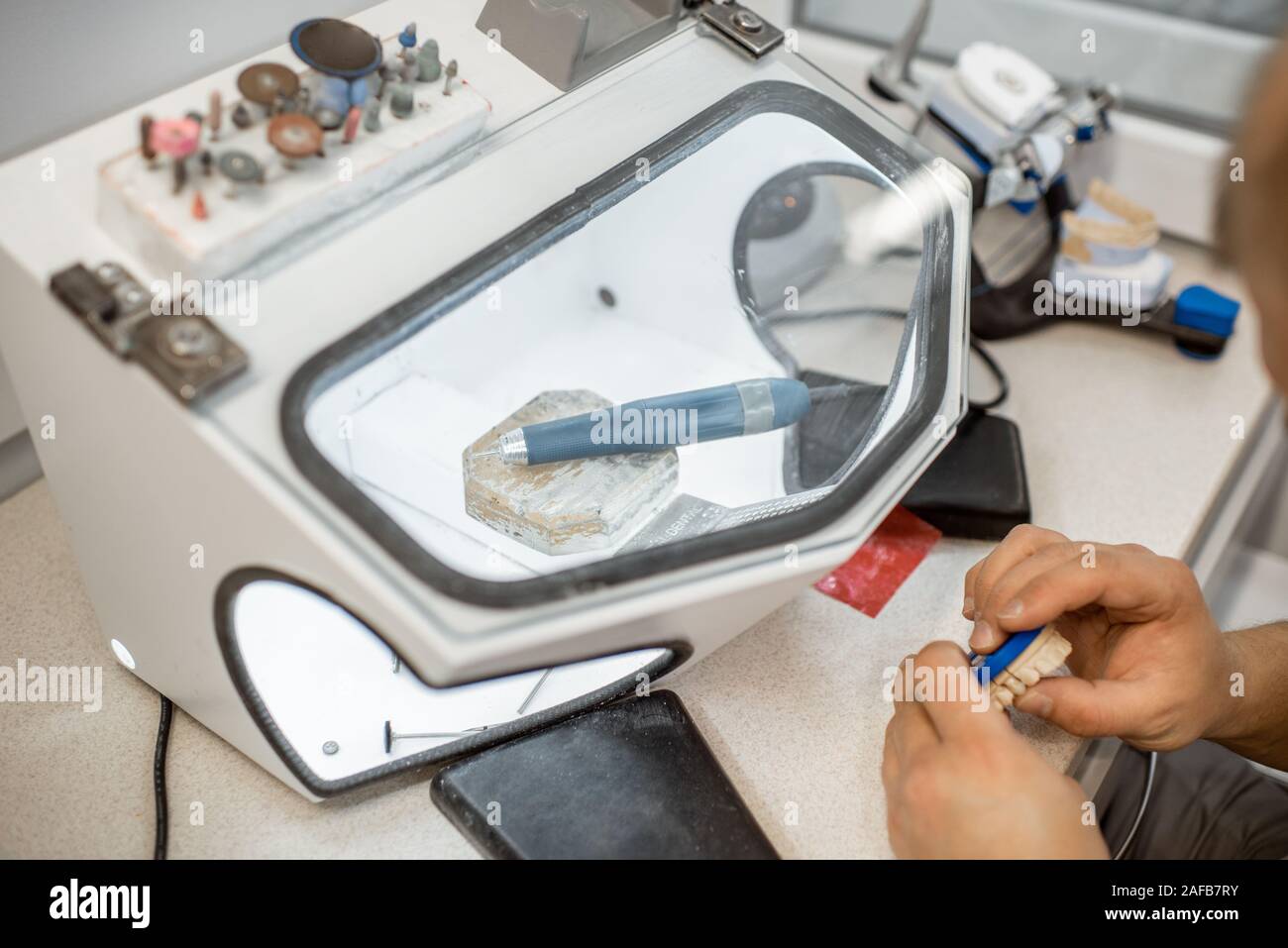 Dental technician working on gypsum jaw at the laboratory Stock Photo