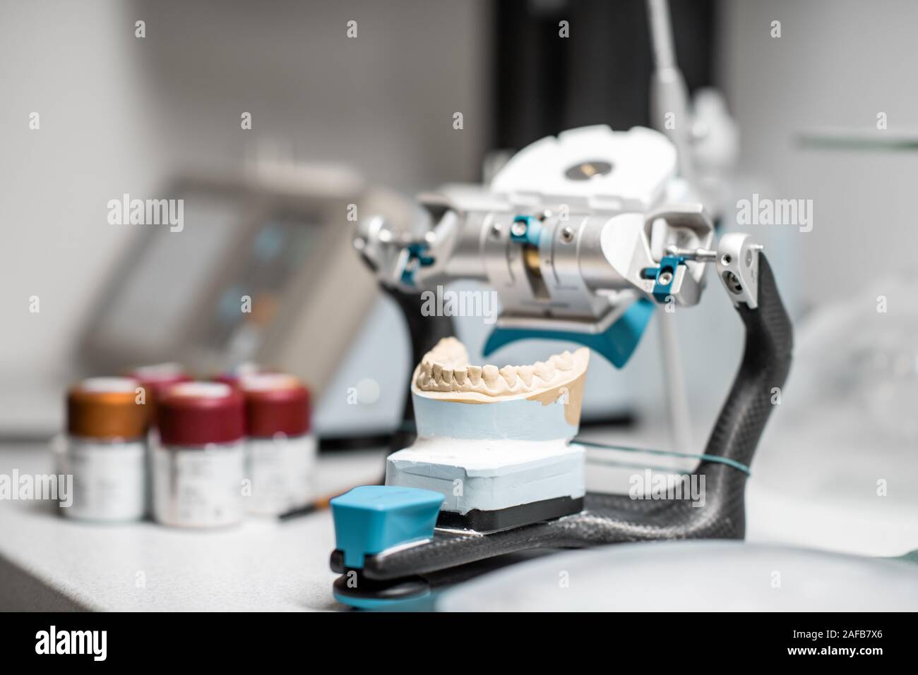 Dental articulator with jaw model on the table at the laboratory Stock Photo