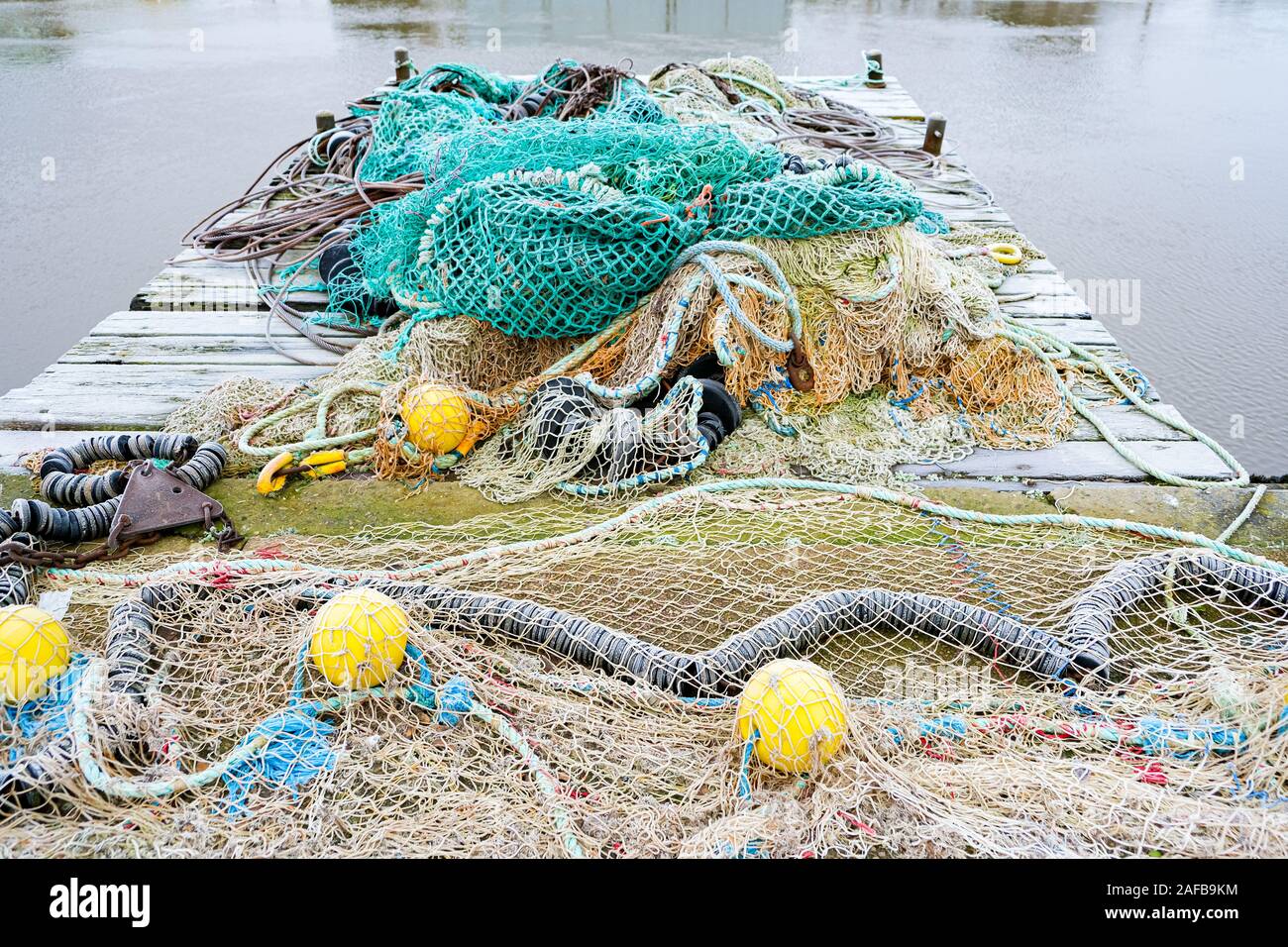 blue fishing net on a pontoon with its ropes and floats covered with ...