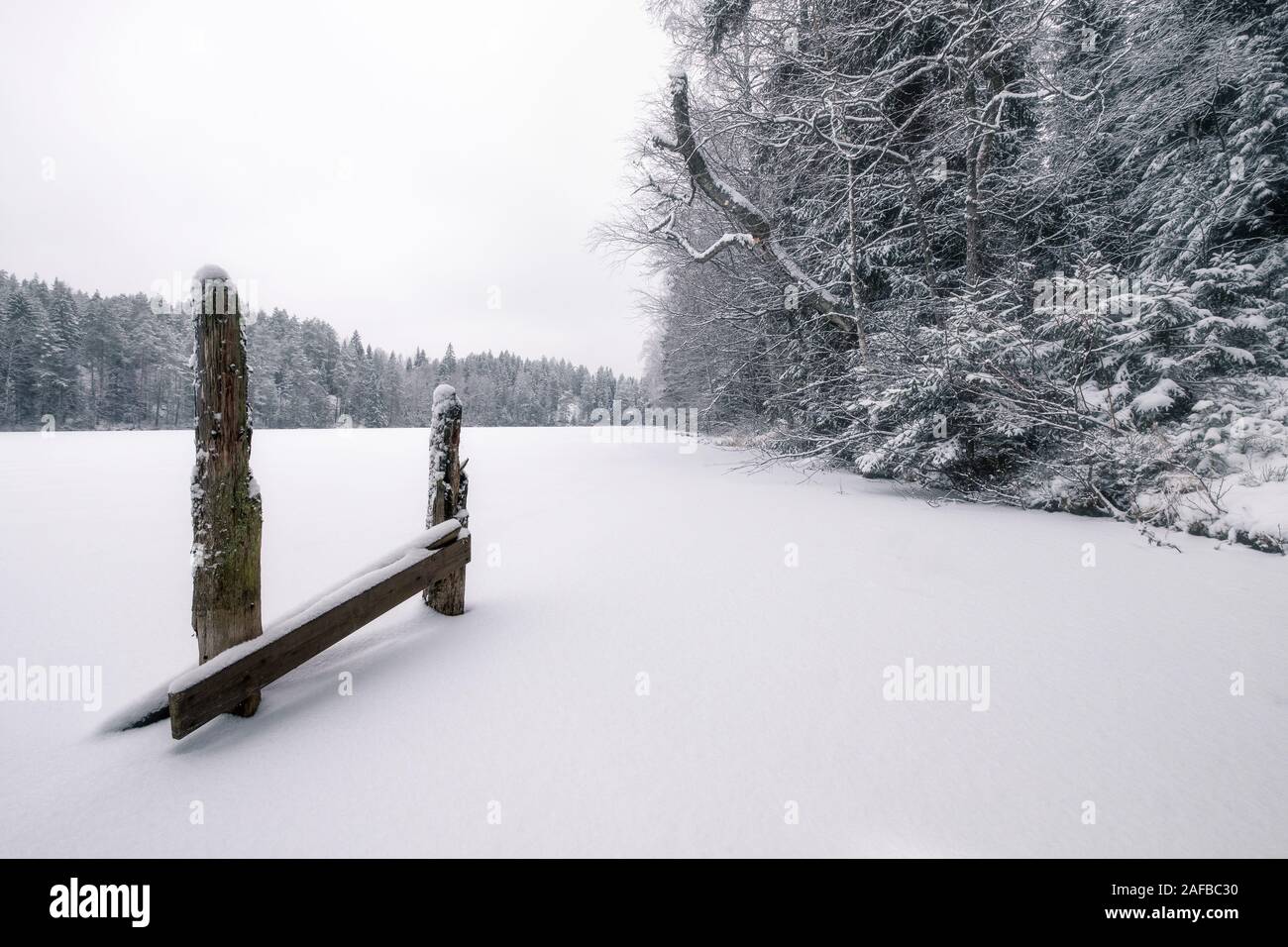 White snowy landscape with wooden fence at mood winter day in Finland Stock Photo