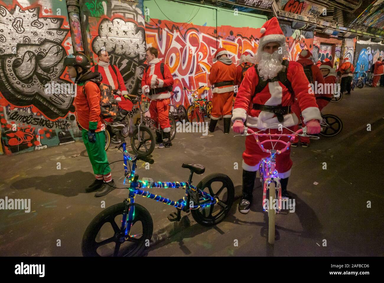 London, UK. 14th Dec, 2019. Hundreds of BMX riders from BMX Life and House  of Vans London dressed as Santas (with a few elves) meet in the graffiti  tunnel at Leake St