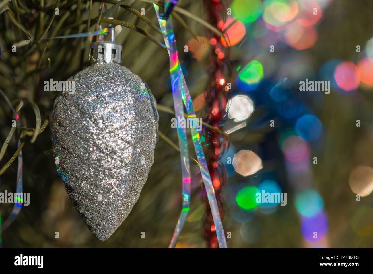 Christmas tree cone silver color on a decorated Christmas tree. Christmas backgroung Stock Photo