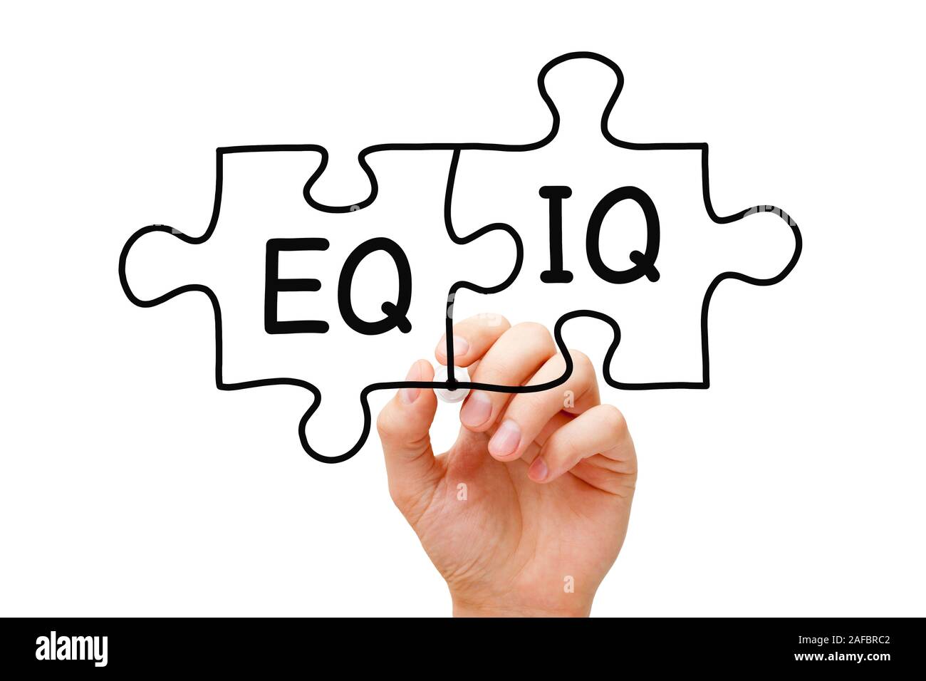 Hand writing EQ and IQ on jigsaw puzzle with black marker on transparent wipe board. Concept about the importance of both the Emotional Intelligence Q Stock Photo