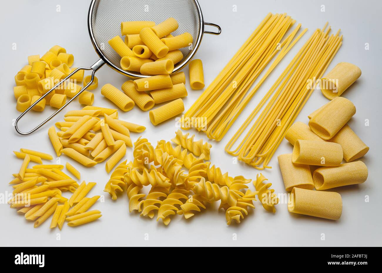 colander and different types of pasta, viewed from above Stock Photo