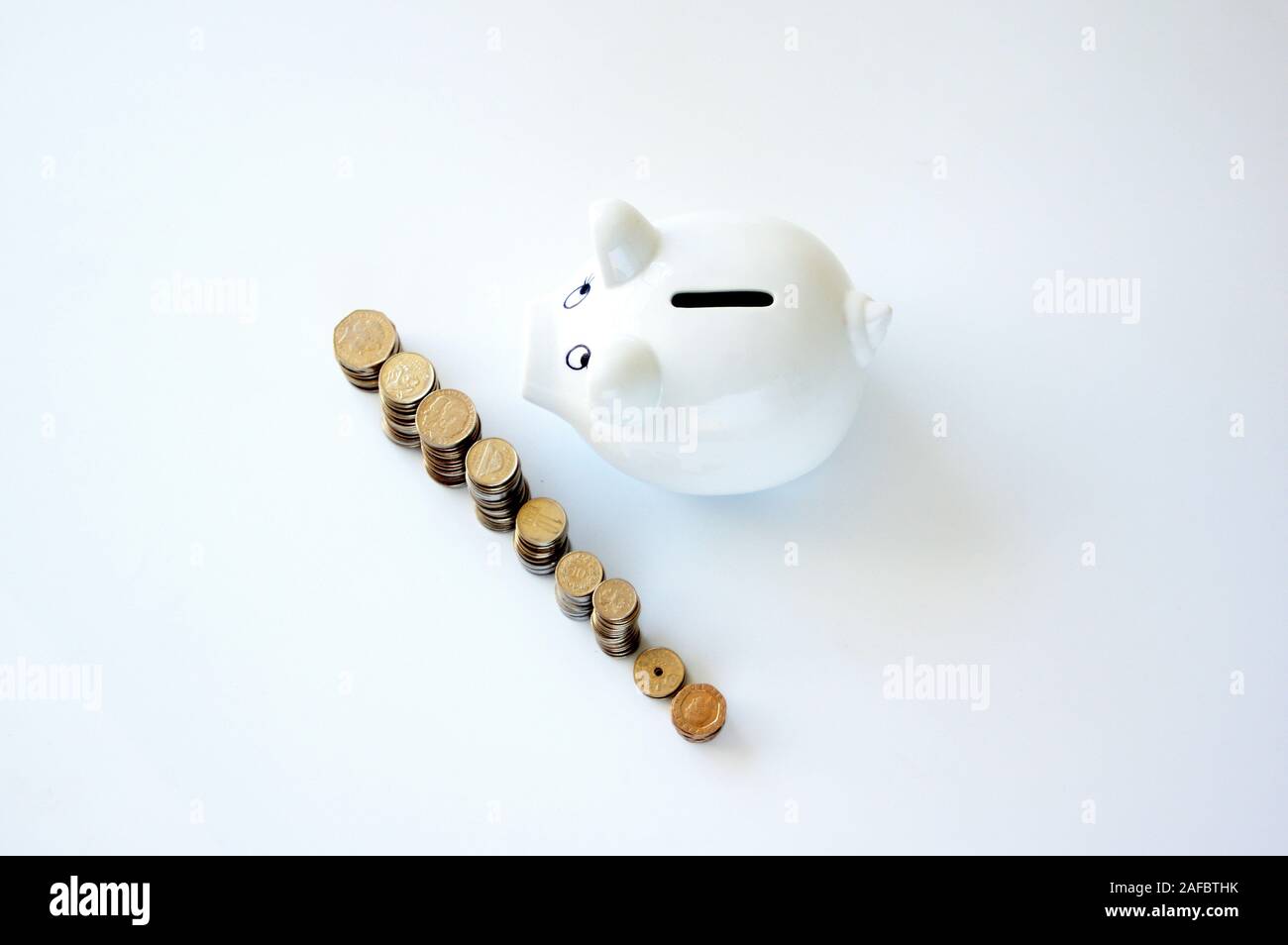 Piggy bank with stack of coin on white Stock Photo - Alamy