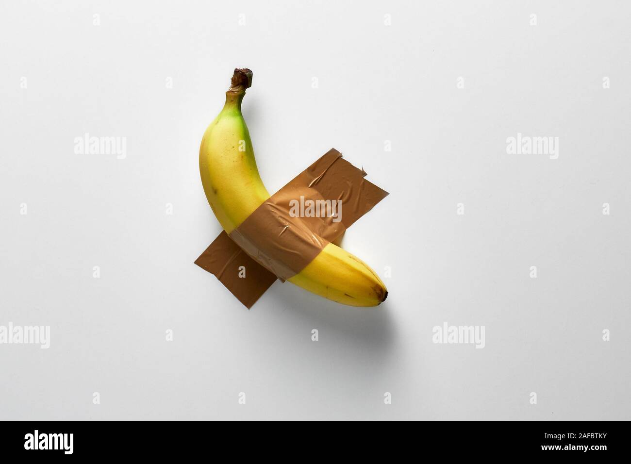 Popular conceptual photo trend, banana duct-taped to a white wall Stock Photo