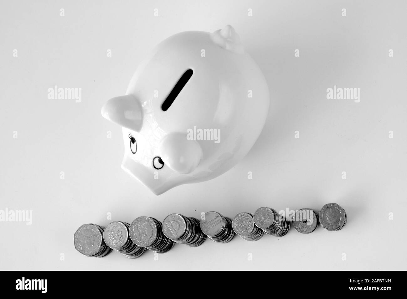 Piggy bank with stack of coin on white Stock Photo - Alamy
