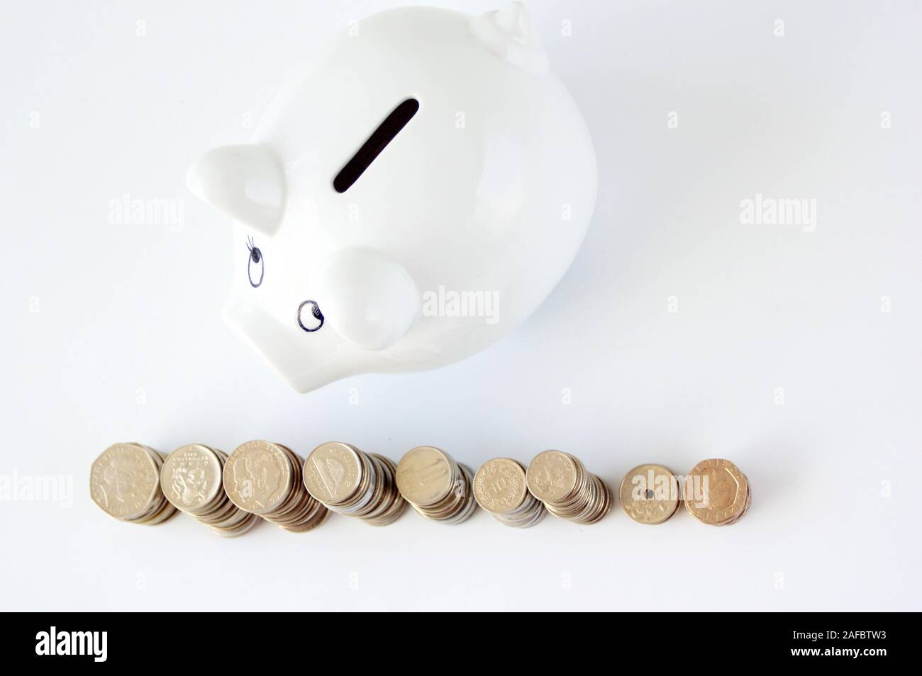 Piggy bank with stack of coin on white Stock Photo - Alamy