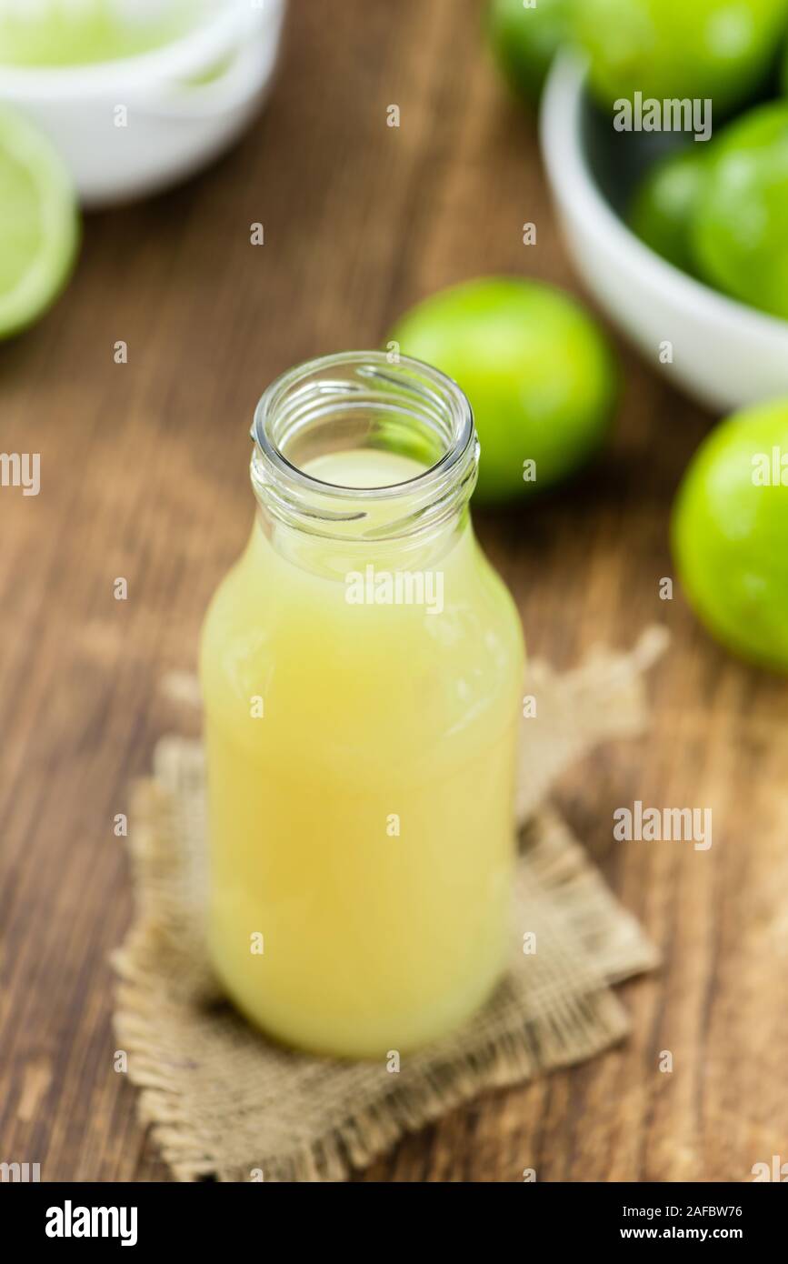 Fresh Lime Juice as high detailed close-up shot on a vintage wooden table (selective focus) Stock Photo