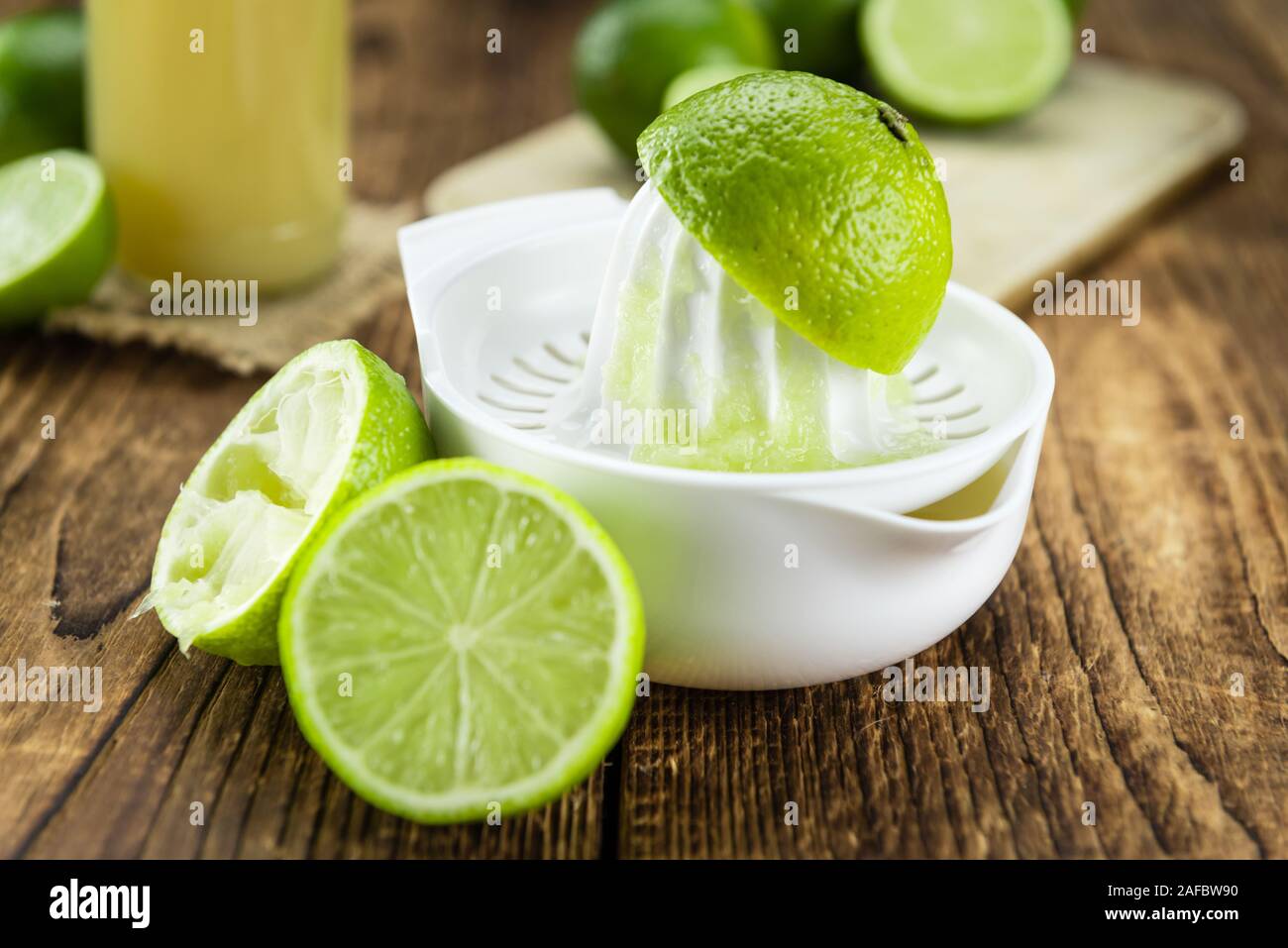 Fresh made Fresh Lime Juice on an old and rustic wooden table (selective focus, close-up shot) Stock Photo