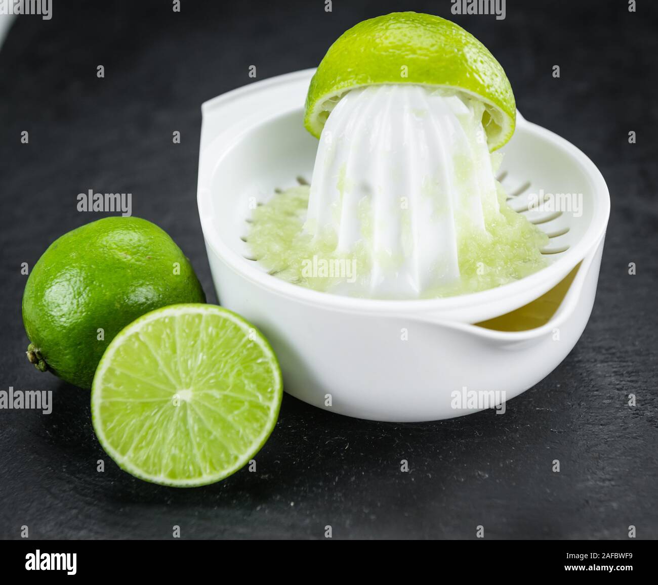 Portion of Fresh Lime Juice on a rustic slate slab (selective focus; close-up shot) Stock Photo