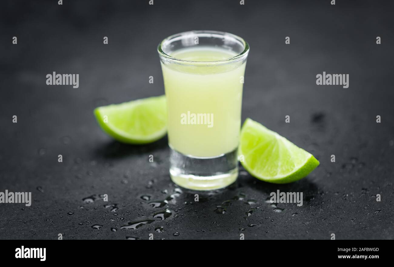 Portion of Fresh Lime Juice on a rustic slate slab (selective focus; close-up shot) Stock Photo