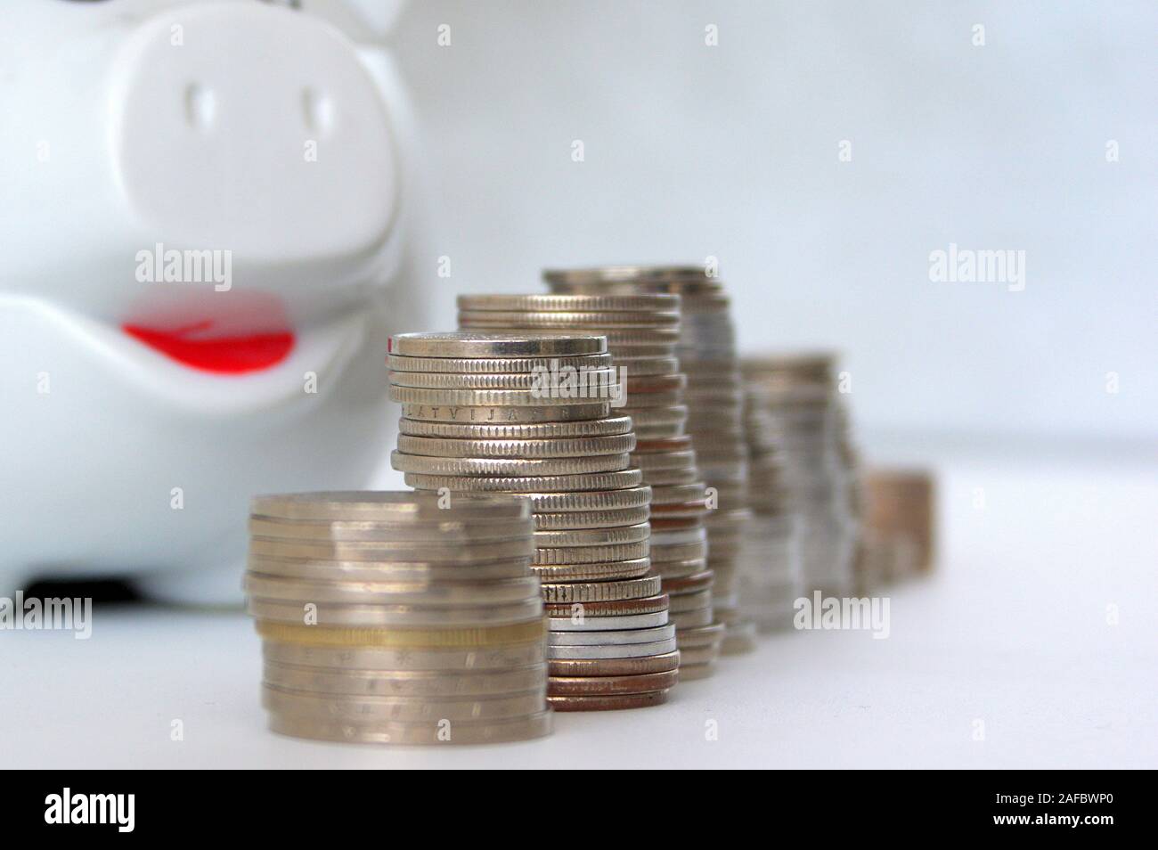 Piggy bank with stack of coin on white Stock Photo - Alamy