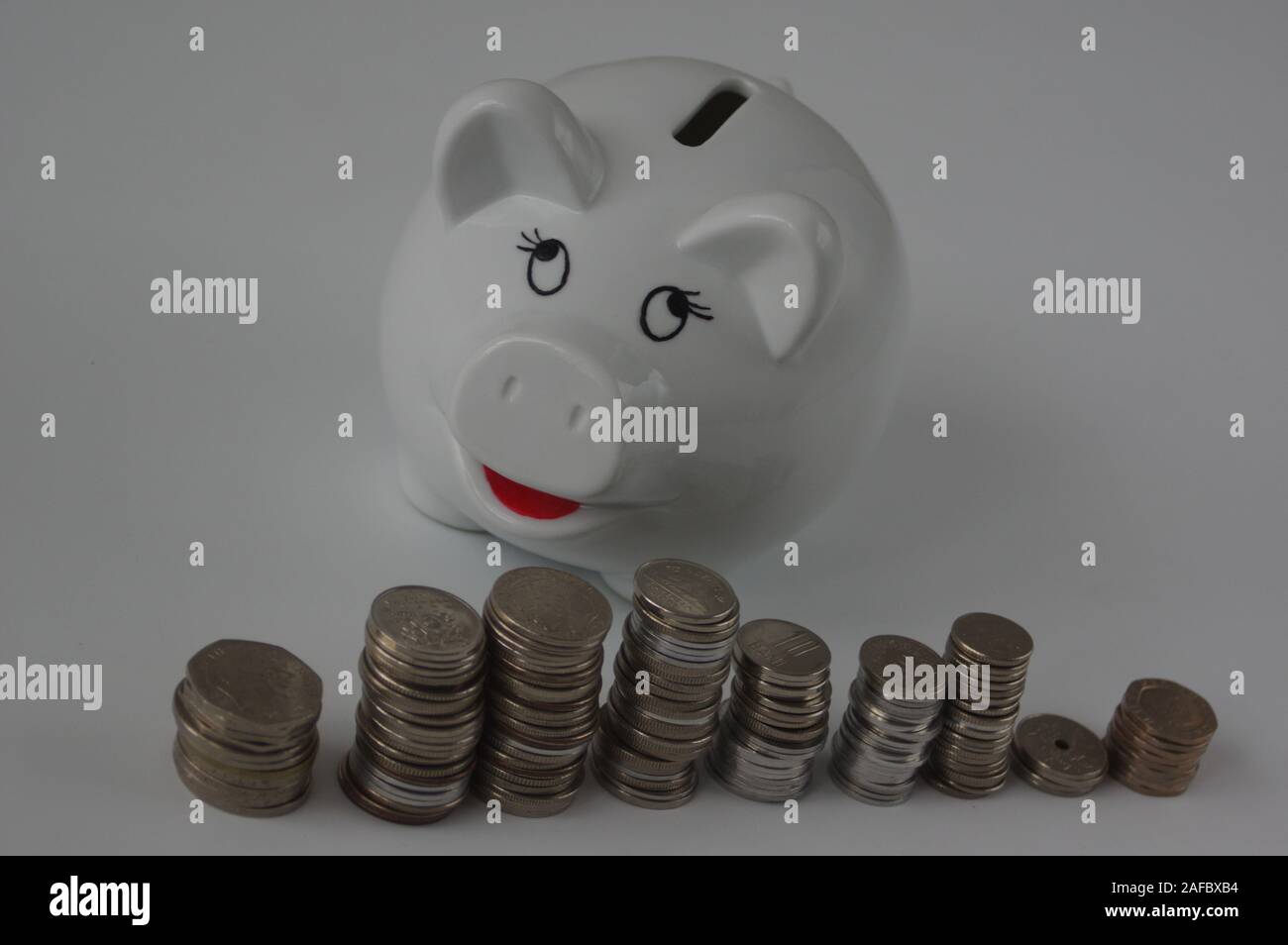 Piggy bank with stack of coin on white Stock Photo - Alamy
