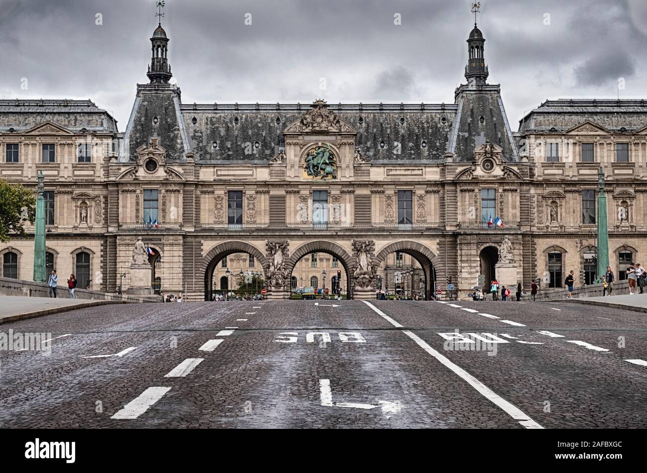 Street lanes on a bridge over the Seine River lead from and to the Louvre Palace in Paris. Stock Photo