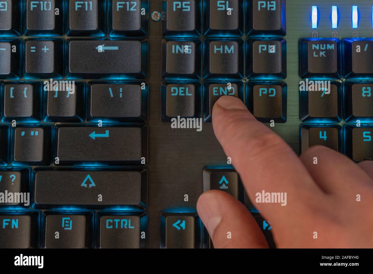 male finger presses the end key on the backlit keyboard Stock Photo Alamy