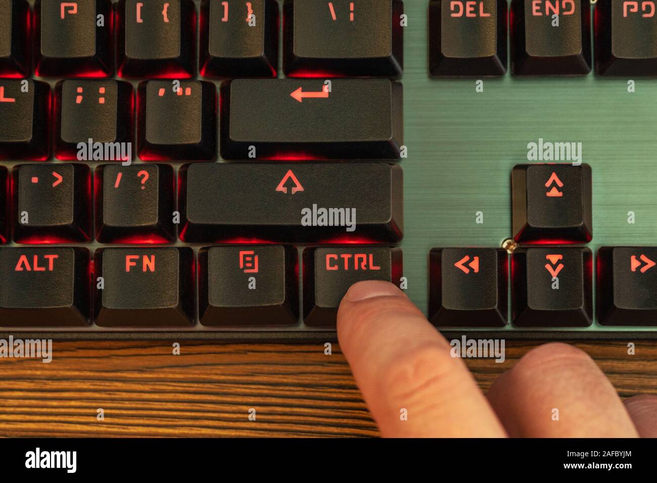 index finger of a male hand presses the control key on a black keyboard