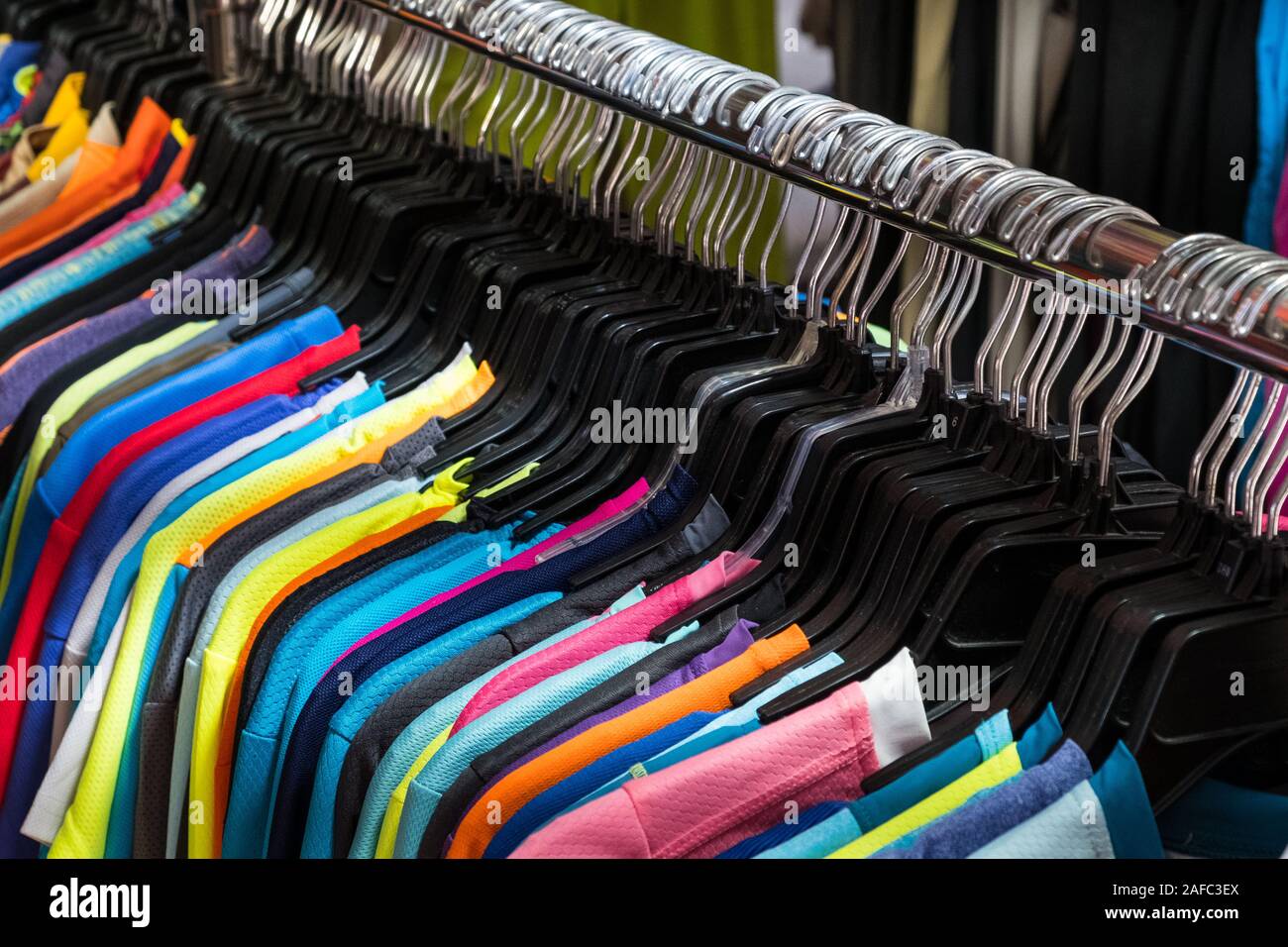 colorful t-shirts hanging on second hand clothing market Stock Photo