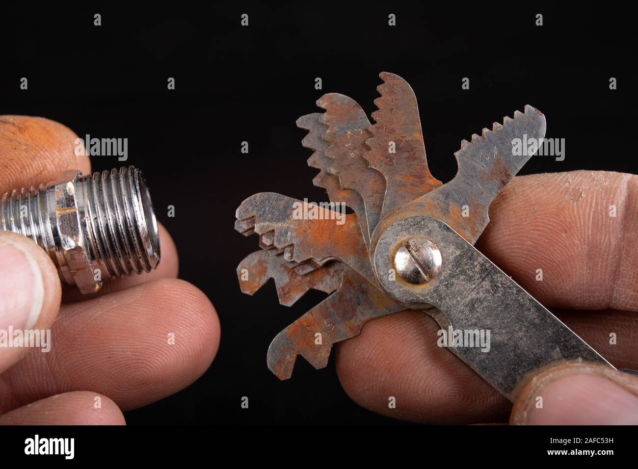 Checking the screw thread with an analog meter. Correctness of the threaded connection. Dark background. Stock Photo