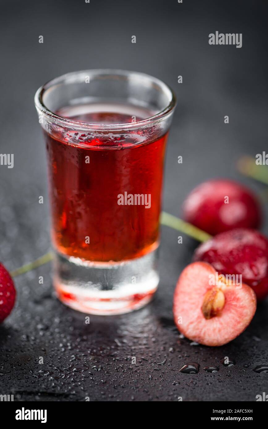 Homemade Cherry Liqueur on vintage background selective focus; close-up shot Stock Photo