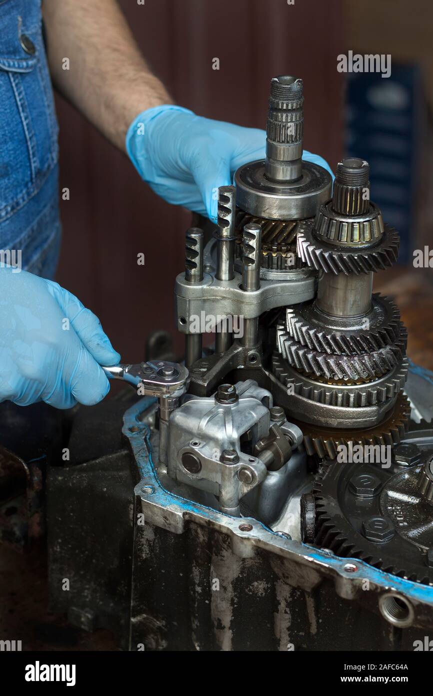 Mechanic repairing the car's gearbox. Unscrewing a socket with a damaged gearbox Stock Photo Alamy
