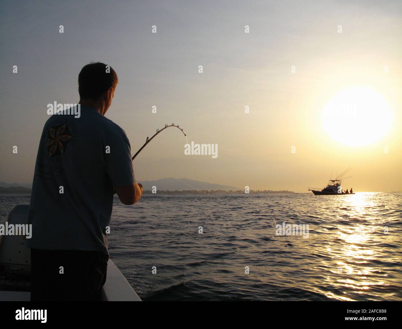 Man fishing in the sea at sunrise near Puerto Vallarta, Mexico. Model Released Photo Stock Photo