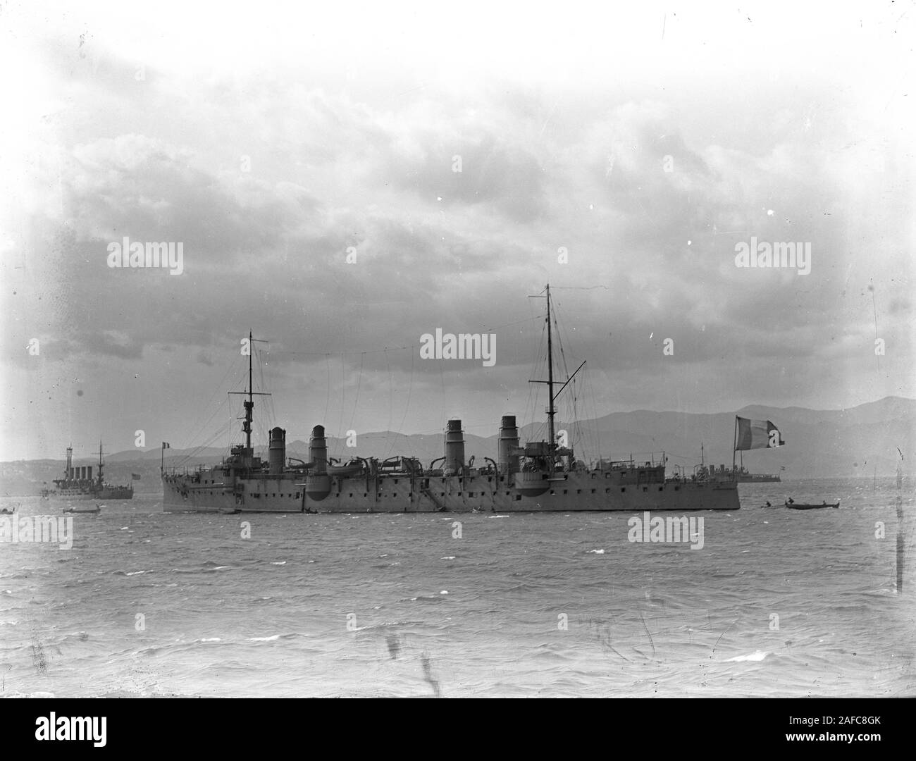 Regia Marina Italy warship vessel San Giorgio class of armored cruisers: San Giorgio or San Marco in the waters of Trieste. To the left probably a Royal Navy cruiser of Cressy class. Third ship with a k.k. Kriegsmarine flag, probably Habsburg class, behind the stern of San Giorgio, therefore probably before 1914 or after end of war 1918. Copy from  a dry glass plate, originating from the Herry W. Schaefer collection. Stock Photo