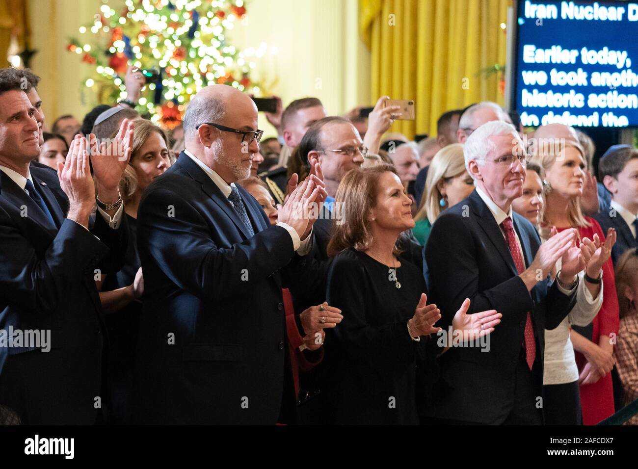 Washington, United States Of America. 11th Dec, 2019. Israeli Ambassador to the United States Ron Dermer and conservative commentator Mark Levin join guests as they applaud President Donald J. Trump during a Hanukkah Reception Wednesday, Dec. 11, 2019, in the East Room of the White House People: Israeli Ambassador to the United States Ron Dermer and conservative commentator Mark Levin Credit: Storms Media Group/Alamy Live News Stock Photo