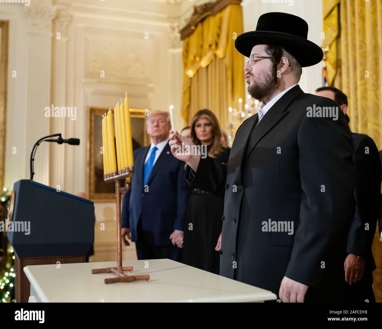 Washington, United States Of America. 11th Dec, 2019. President Donald J. Trump and First Lady Melania Trump look on as Rabbi Moshe Moskowitz lights the Menorah during a Hanukkah Reception Wednesday, Dec. 11, 2019, in the East Room of the White House People: President Donald J. Trump, Rabbi Moshe Moskowitz Credit: Storms Media Group/Alamy Live News Stock Photo