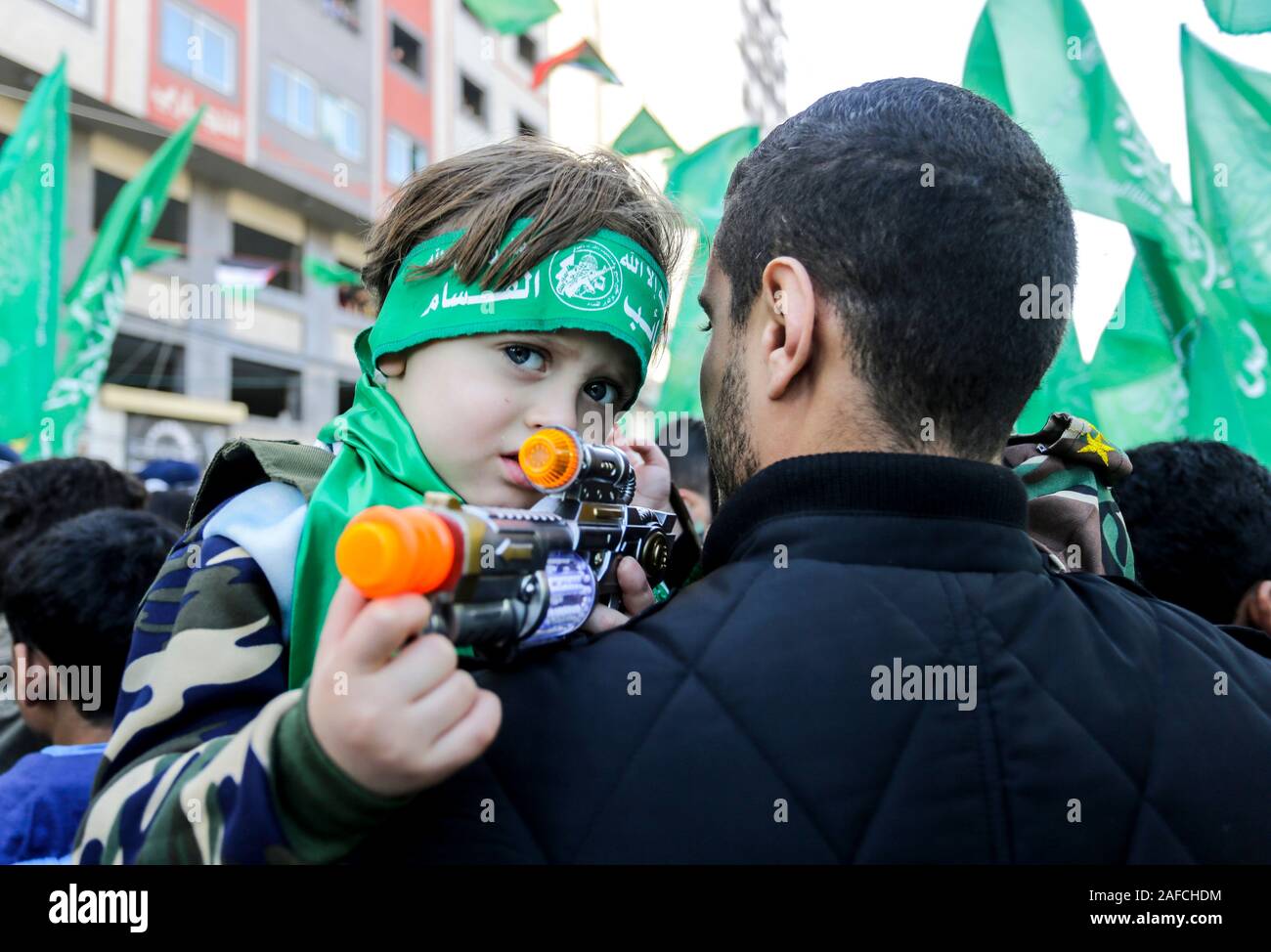 Palestinian Hamas kid supporter with a toy gun during a rally marking the 32nd anniversary of the founding of the Islamist movement Hamas. Stock Photo