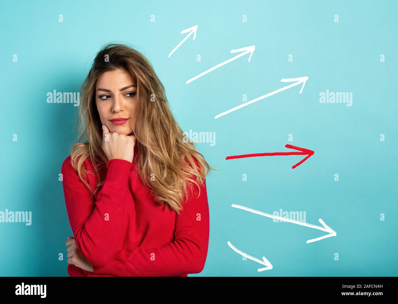 Confused woman have to choose the right arrow to follow. Concept of options, confusion, decision. Stock Photo