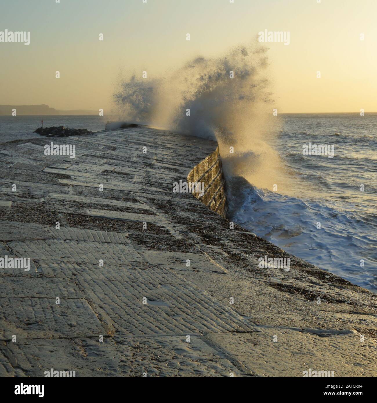 Big waves splashing on the Cobb in Lyme Regis, Dorset caused by gusty