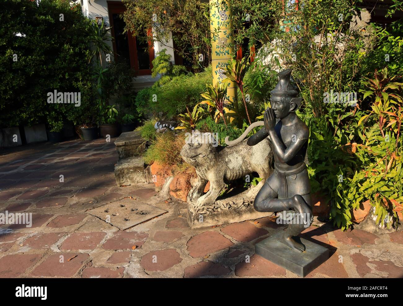 Hermit statue at Wat Pho or ruesi datton performing one position of Thai yoga by pressing the hands together and standing on one leg Stock Photo