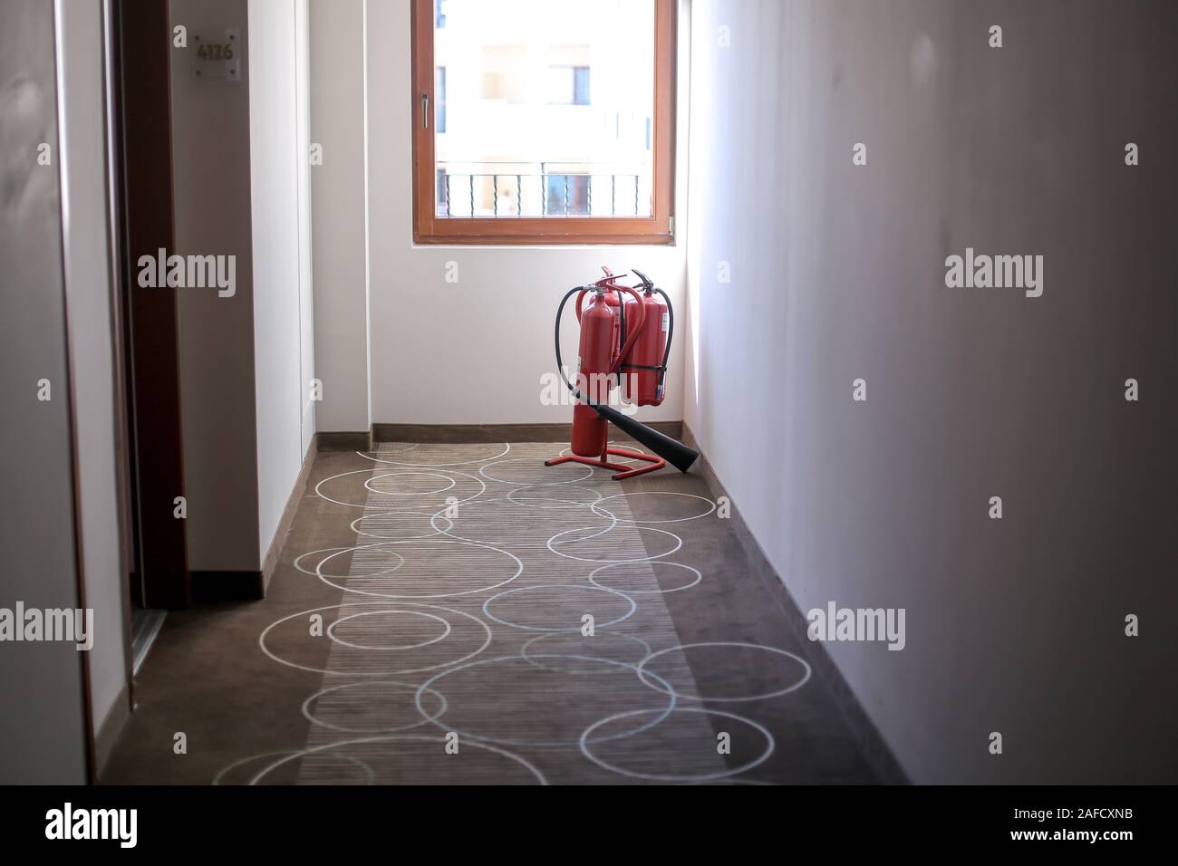 Different types of fire extinguishers on the hallway of a hotel Stock Photo